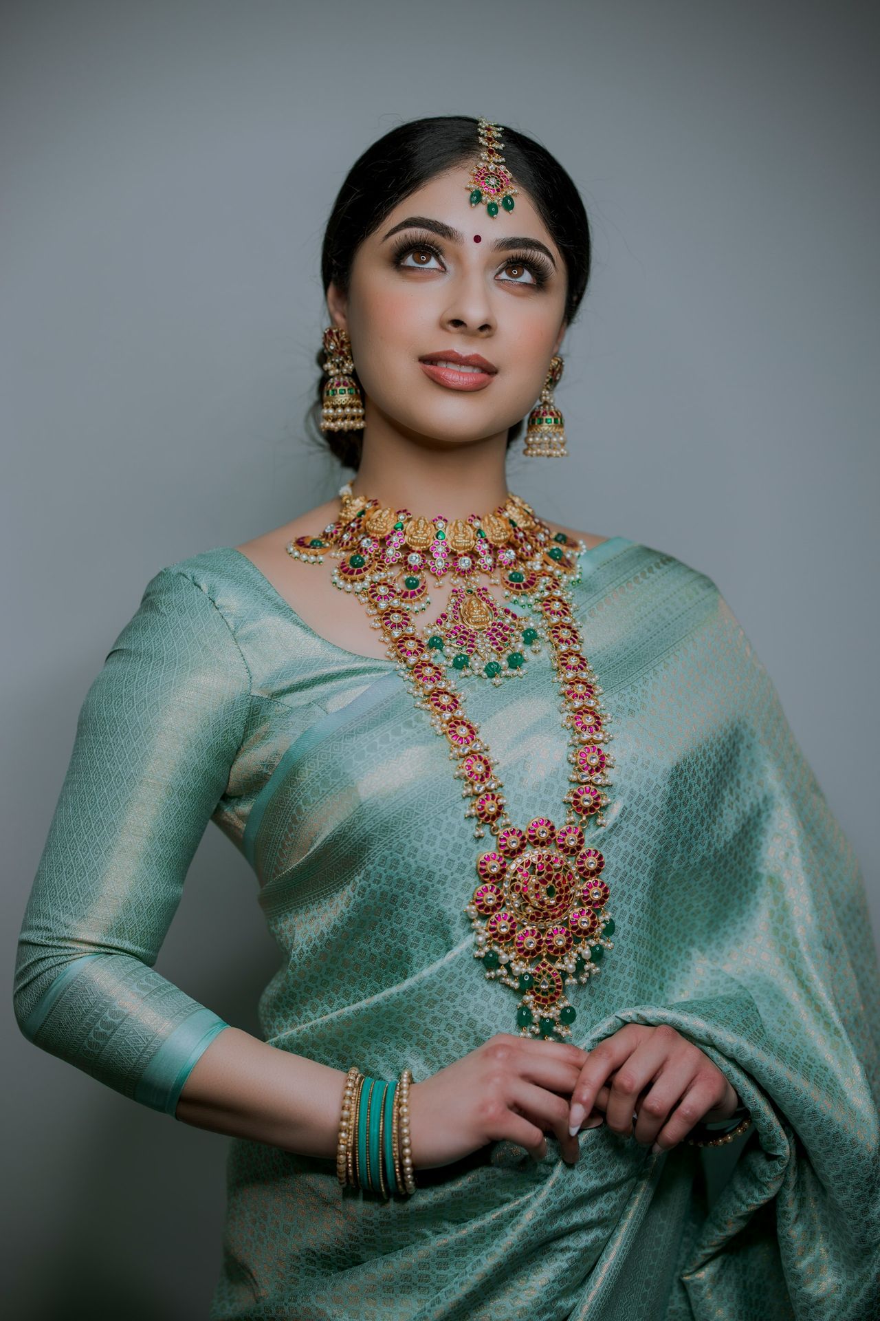 a woman wearing a green sari and jewelry